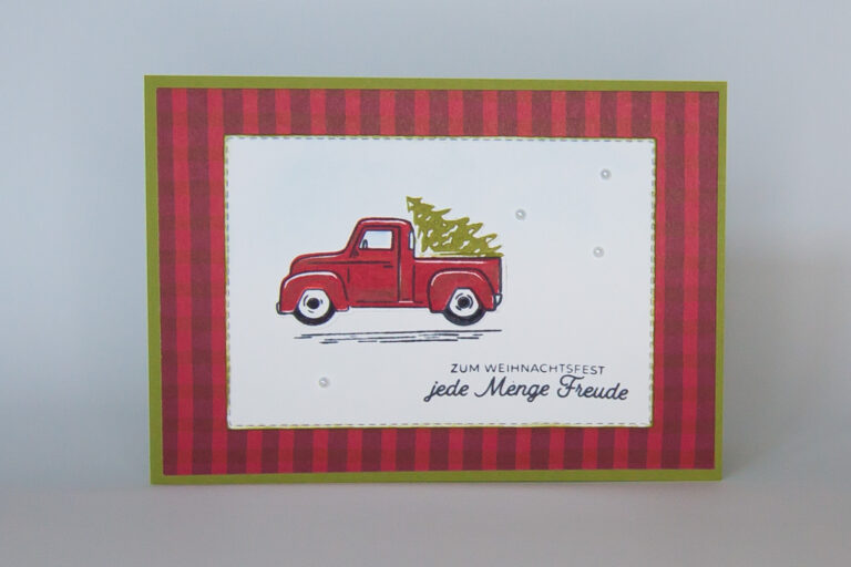 Eine festliche Weihnachtskarte mit einem roten LKW, der einen wunderschön geschmückten Baum transportiert. Der perfekte Weg, um Feiertagsfreude und -freude zu verbreiten!
