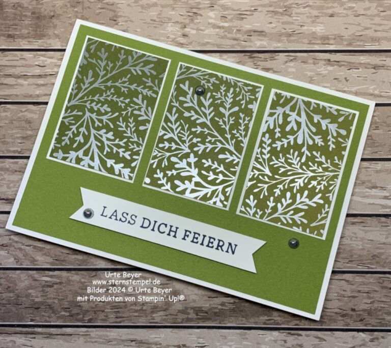 Eine handgefertigte grüne Grußkarte mit drei weißen botanischen Feldern und dem Text „LASS DICH FEIERN“ auf einer Holzoberfläche, perfekt zum Feiern von Mach was draus am 24. Juni.