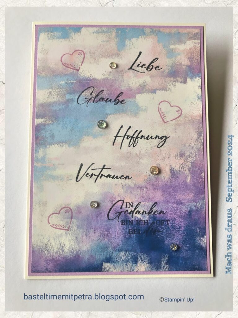 Handgefertigte Karte mit pastellfarbenem Aquarellhintergrund mit den deutschen Worten „Liebe, Glaube, Hoffnung, Vertrauen“ und kleinen Herzen und Glitzer verziert. Perfekt, um am 24. September einen Hauch Wärme zu verbreiten – Mach was draus!