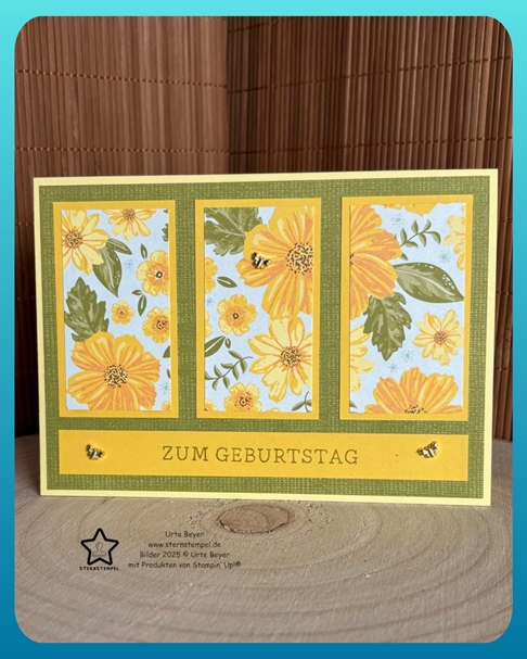 Grußkarte mit drei floralen Tafeln mit gelben Blumen und Bienen, mit der Aufschrift „Zum Geburtstag“ auf einer Holzoberfläche, perfekt für alle, die am 25. Februar geboren sind.