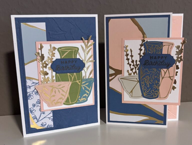 Zwei handgefertigte Geburtstagskarten mit dekorativen Vasenmotiven, Goldfolienakzenten und "Happy Birthday"-Botschaften auf blauem, rosa und weißem Hintergrund - perfekt, um Mach was draus 25. Juli stilvoll zu feiern.