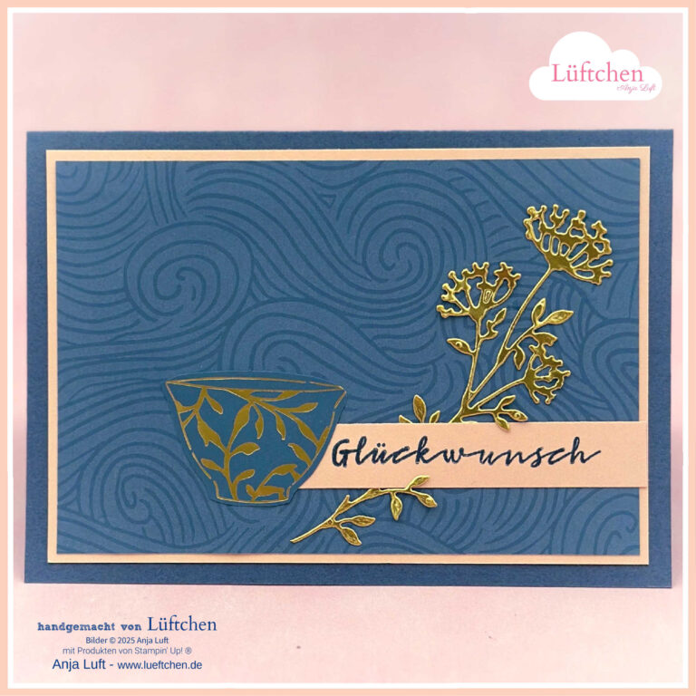 Kintsugi - Mach, wurde am 25. Juli draus, mit blauen geprägten Wirbeln, goldenen Blumenakzenten, einer goldenen Teetasse und einem "Glückwunsch"-Etikett auf der Vorderseite.