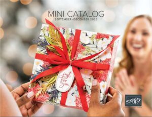 Hände präsentieren eine blumengeschmückte Geschenkschachtel mit roter Schleife und "just for you"-Anhänger; eine lächelnde Frau im Hintergrund. Der Text lautet "MINI-KATALOG September-Dezember 2025". Jetzt Stampin' Up! Katalog 2025 bestellen!.