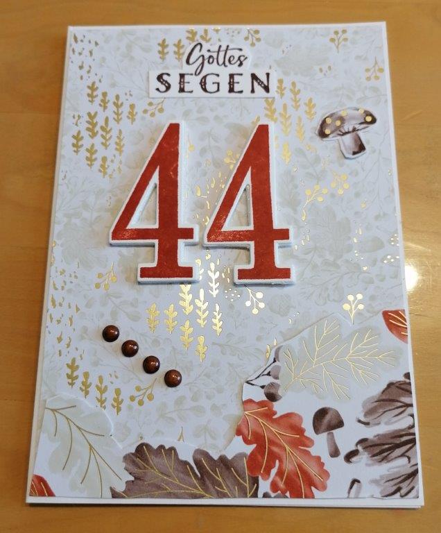 Eine dekorative Karte mit dem Text "Gottes Segen" und der Zahl 44, mit Herbstblättern, Eicheln, einem Pilz, Goldfolienakzenten und inspiriert von Mach wurde am 25. September draus.