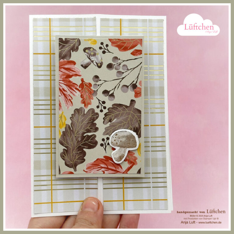 Eine Hand hält eine handgefertigte Karte mit herbstlichen Blatt- und Pilzmotiven auf kariertem Hintergrund; in der rechten oberen Ecke erscheint der Schriftzug "Lüftchen", der für Mach was draus am 25. September geschaffen wurde.