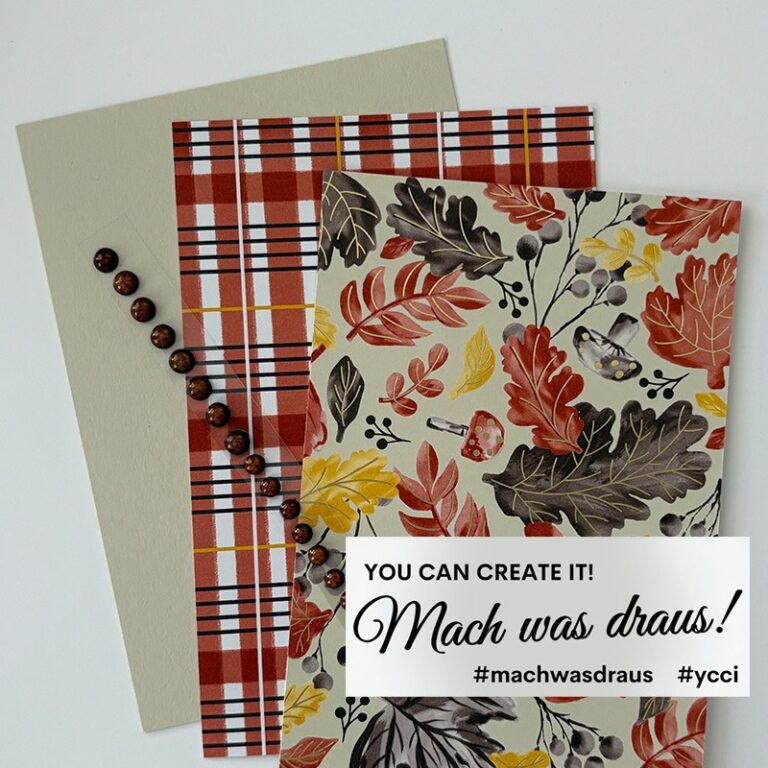 Drei Blätter gemustertes und einfarbiges Papier, ein Strang brauner Perlen und ein Etikett mit der Aufschrift "YOU CAN CREATE IT! Mach was draus 25. September #machwasdraus #ycci" sind auf einer weißen Fläche angeordnet.