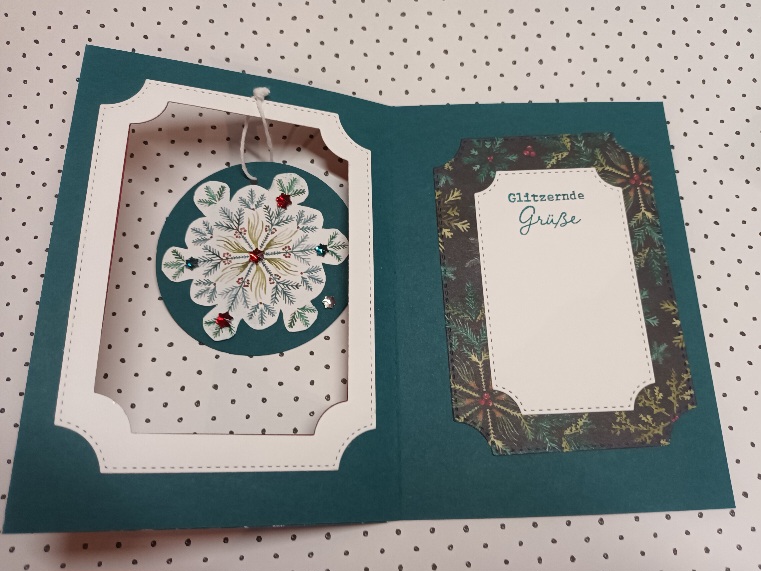Eine offene Feiertagskarte von Mach war draus 25. Oktober mit einer hängenden 3D-Schneeflocke auf der linken Seite und einem gerahmten Nachrichtenfeld auf der rechten Seite, auf dem "Glitzernde Grüße" auf grünem und weißem Hintergrund steht.