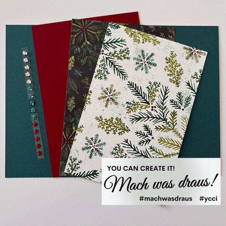Zwei Bögen Dekorationspapier mit weihnachtlichen Motiven und ein Streifen mit Strasssteinen sind auf dunkelgrünem Hintergrund zu sehen. Auf einem Etikett steht: "Du kannst es schaffen! Mach was draus 25. Oktober.