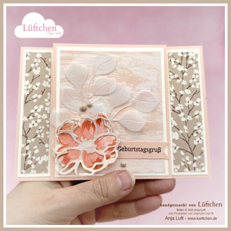 Eine handgefertigte Geburtstagskarte mit einem Blumen- und Blattmotiv in zarten Rosa- und Beigetönen, die in einer Hand gehalten wird. Diese Karte mit der Aufschrift "Geburtstagsgruß" von Petals of Beauty hat dekorative, gemusterte Paneele, die ihr einen eleganten Touch verleihen.