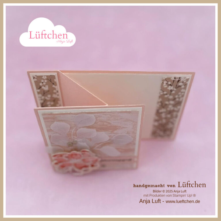 Eine handgefertigte, gefaltete Grußkarte mit floralen Mustern und rosafarbenen Akzenten aus der Petals of Beauty-Kollektion, aufrecht stehend auf einem zartrosa Hintergrund mit Luftchen-Branding in den Ecken.