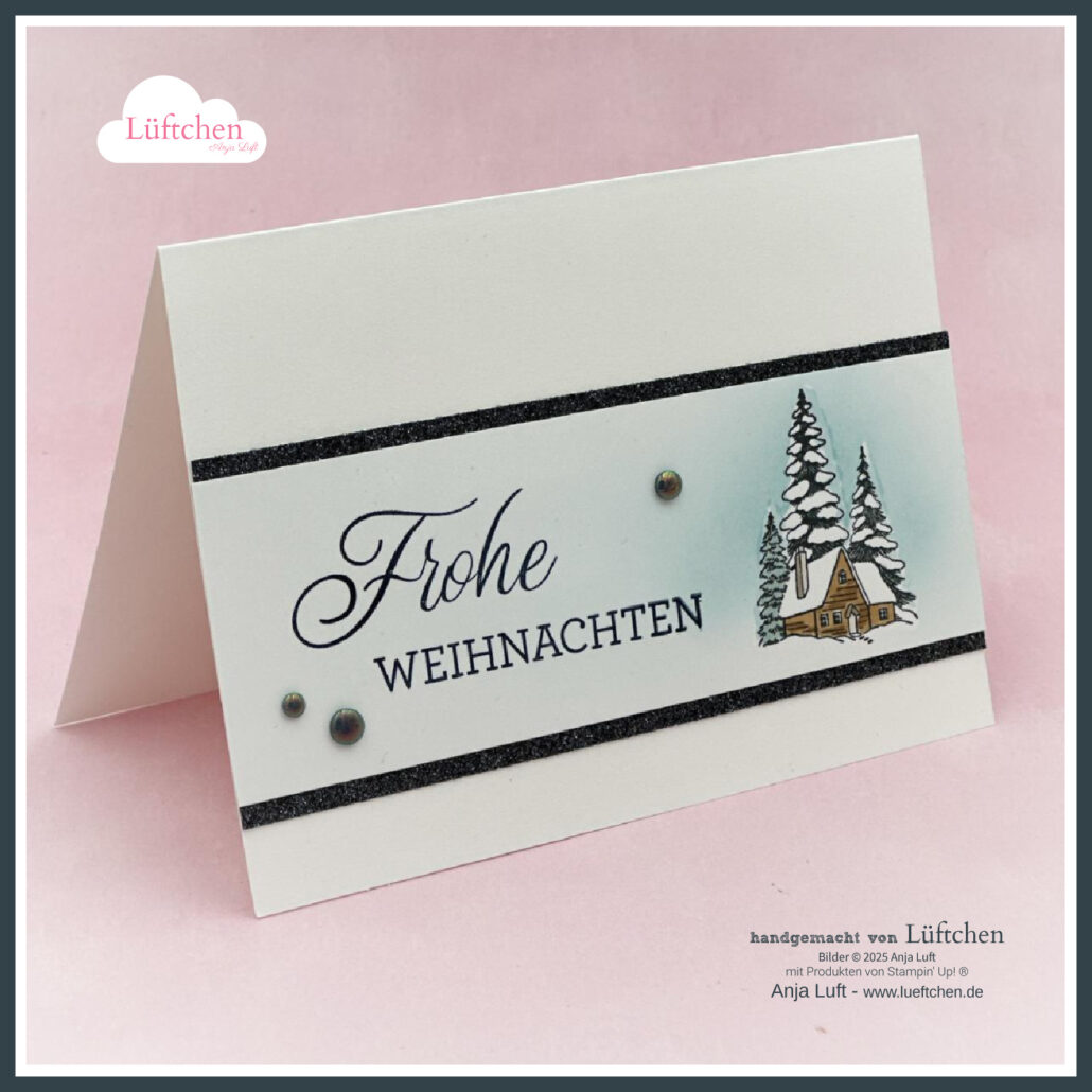 Eine handgefertigte Weihnachtskarte mit dem deutschen Text "Frohe Weihnachten 25", verziert mit einem kleinen Haus, verschneiten Bäumen und schwarzen Glitzerrändern auf weißem Hintergrund.