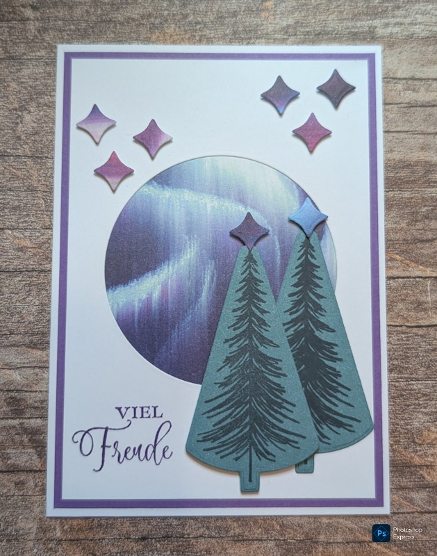 Die handgefertigte Karte für Mach was draus 25. Oktober zeigt zwei illustrierte Tannenbäume, einen kreisförmigen Nordlicht-Hintergrund, lila Rauten und den Aufdruck Viel Freude" in der linken unteren Ecke.
