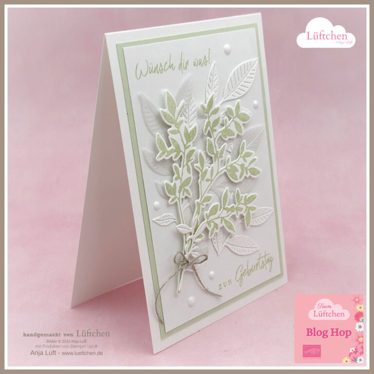 Eine handgefertigte Geburtstagskarte mit grünen und weißen Blattmotiven aus dem neuen Katalog, mit deutschem Text und Zierperlen, aufrecht stehend auf rosa Hintergrund.