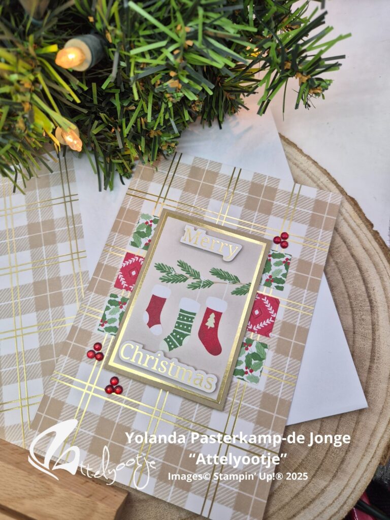 Eine handgefertigte Weihnachtskarte mit Strümpfen und dem Text "Frohe Weihnachten" wird auf einem karierten Hintergrund in der Nähe eines geschmückten Baumes angezeigt, perfekt für Mach was draus 25. Dezember-Feiern.