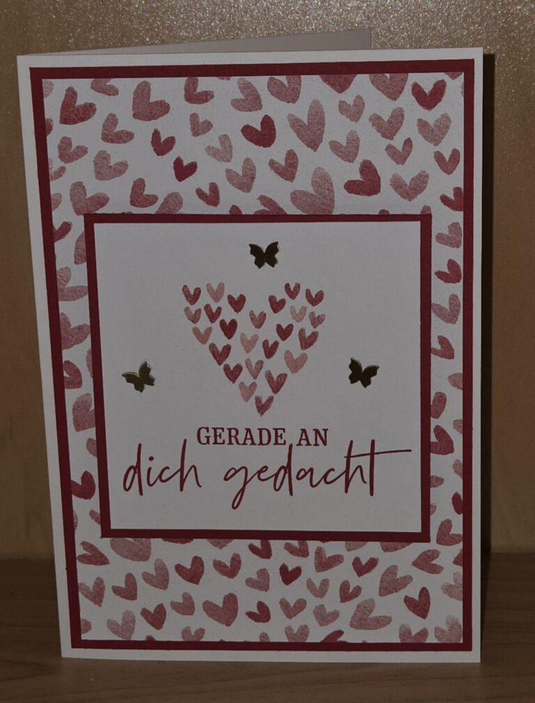 Eine Grußkarte mit roten und rosafarbenen Herzen, drei goldenen Schmetterlingsausschnitten und dem deutschen Text "GERADE, AN dich gedacht" - perfekt für Mach was draus Januar 26 Inspirationen.