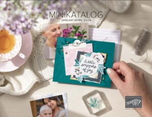 Eine Hand hält eine Karte mit der Aufschrift "little snippets of joy" auf einem Tisch mit Tee, Fotos älterer Frauen, einem klaren Stempelblock und Stampin' Up! Bastelprodukten. Der Text lautet "MINIKATALOG Januar-April 2026".