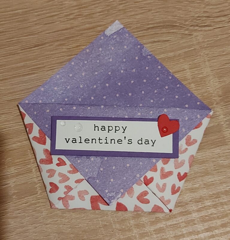 Ein handgefertigter Umschlag mit roten Herzmustern und einer lila Klappe, beschriftet mit "Happy Valentine's Day" und einem kleinen roten Herz - perfekt für Mach war draus 26. Januar Bastelinspiration.