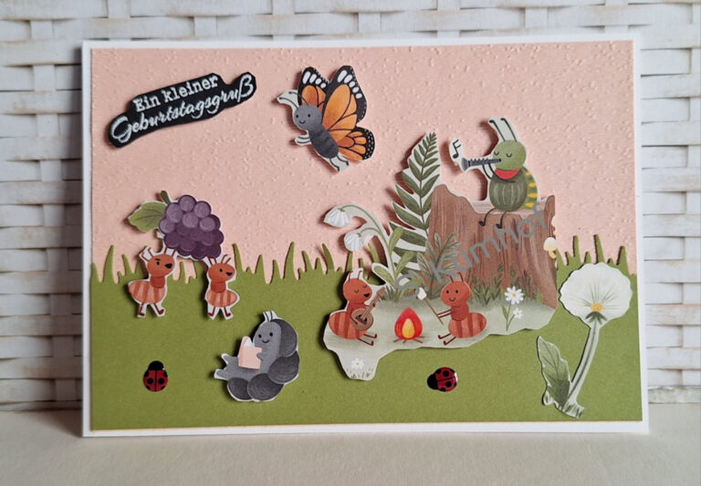 Eine handgefertigte Geburtstagskarte, inspiriert von Mach, wurde am 26. Februar draus, mit Cartoon-Tieren, einem Schmetterling, Pflanzen und Marienkäfern auf einem rosa und grünen Hintergrund; der deutsche Text lautet "Ein kleiner Geburtstagsgruß".