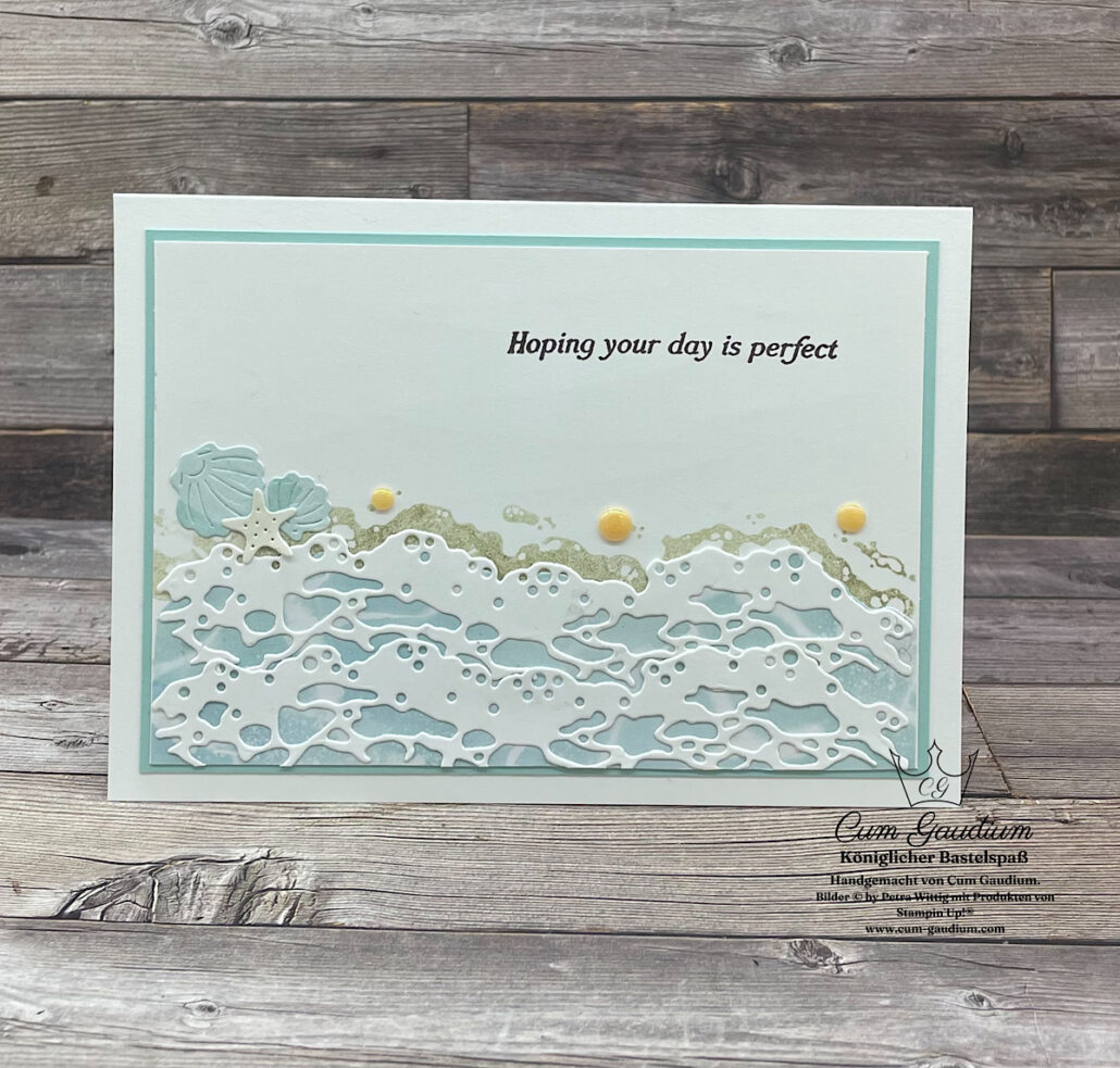 Eine handgefertigte Grußkarte zeigt ein Strand- und Meerschaumdesign mit dem Text "Hoping your day is perfect" auf einem weißen und hellblauen Hintergrund, inspiriert von Mach was draus März 26.