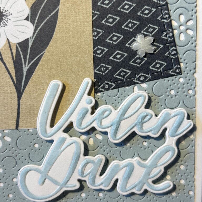 Eine dekorative Karte zeigt die deutschen Worte "Vielen Dank" in Schreibschrift, inspiriert von Mach was draus 26. April, mit floralen und geometrischen Mustern in schwarzen, beigen und blaugrauen Tönen.