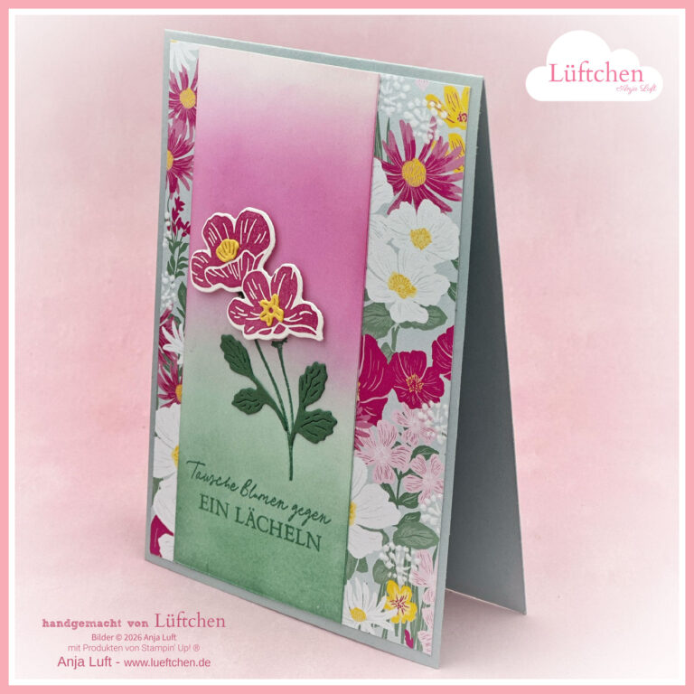 Handgefertigte Grußkarte mit rosafarbenen und gelben Blumen, Blumenbordüren und einem Hintergrund mit Farbverlauf von Rosa zu Grün, auf dem ein deutscher Text steht: "Tausche Blumen gegen EIN LÄCHELN". Entdecken Sie unsere Neuen Produkte - Mai 2026!.