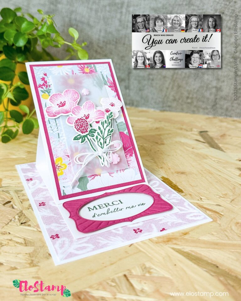 Auf einem Holztisch steht eine handgefertigte Dankeskarte im Staffelei-Stil mit rosa Blumenverzierungen, die für „Mach was draus“ am 26. Mai gestaltet wurde. Im Hintergrund sind eine Pflanze und ein schwarz-weißer Flyer zu sehen.