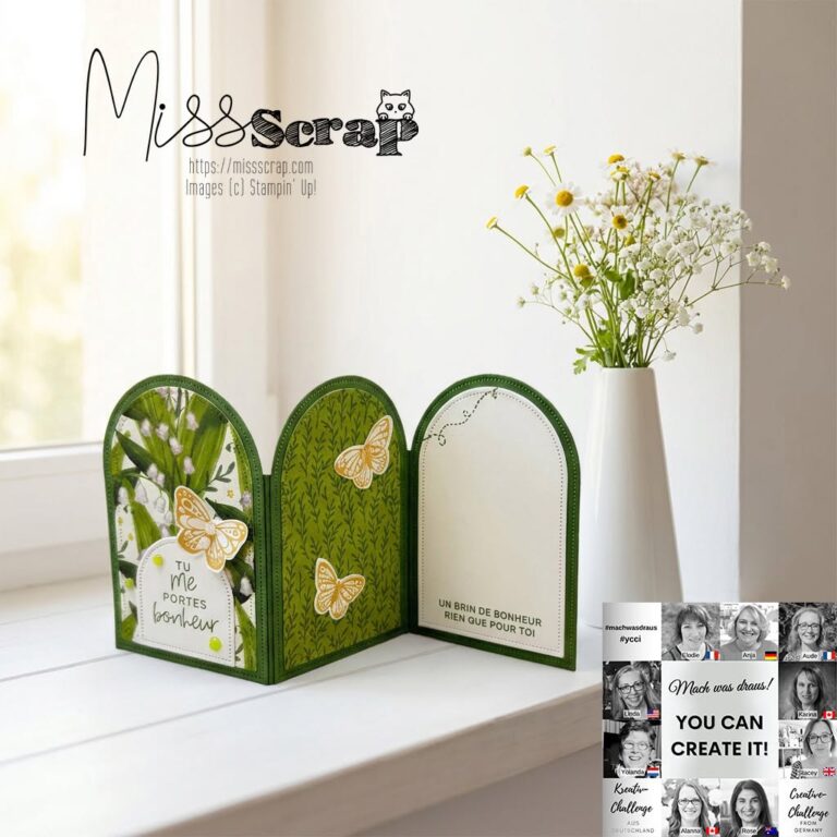 Eine dekorative, dreiteilige, handgefertigte Karte von Mach aus der Ausgabe vom 26. Juni zeigt grüne und weiße Muster, Schmetterlingsmotive und französischen Text und ist auf einem Tisch mit einer Vase voller Blumen zu sehen.