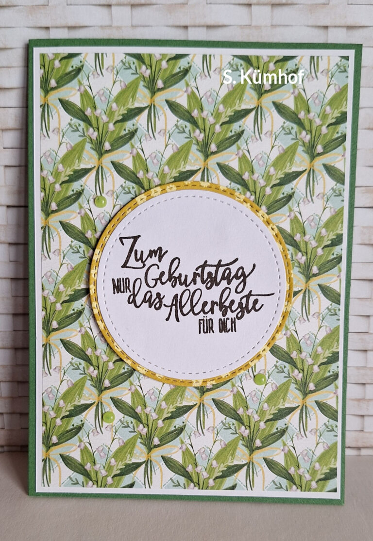Eine handgefertigte Geburtstagskarte mit einem grün-weißen Blumenmuster, inspiriert von „Mach war draus“ vom 26. Juni, zeigt in der Mitte ein rundes Etikett mit der Aufschrift „Zum Geburtstag nur das Allerbeste für dich“.