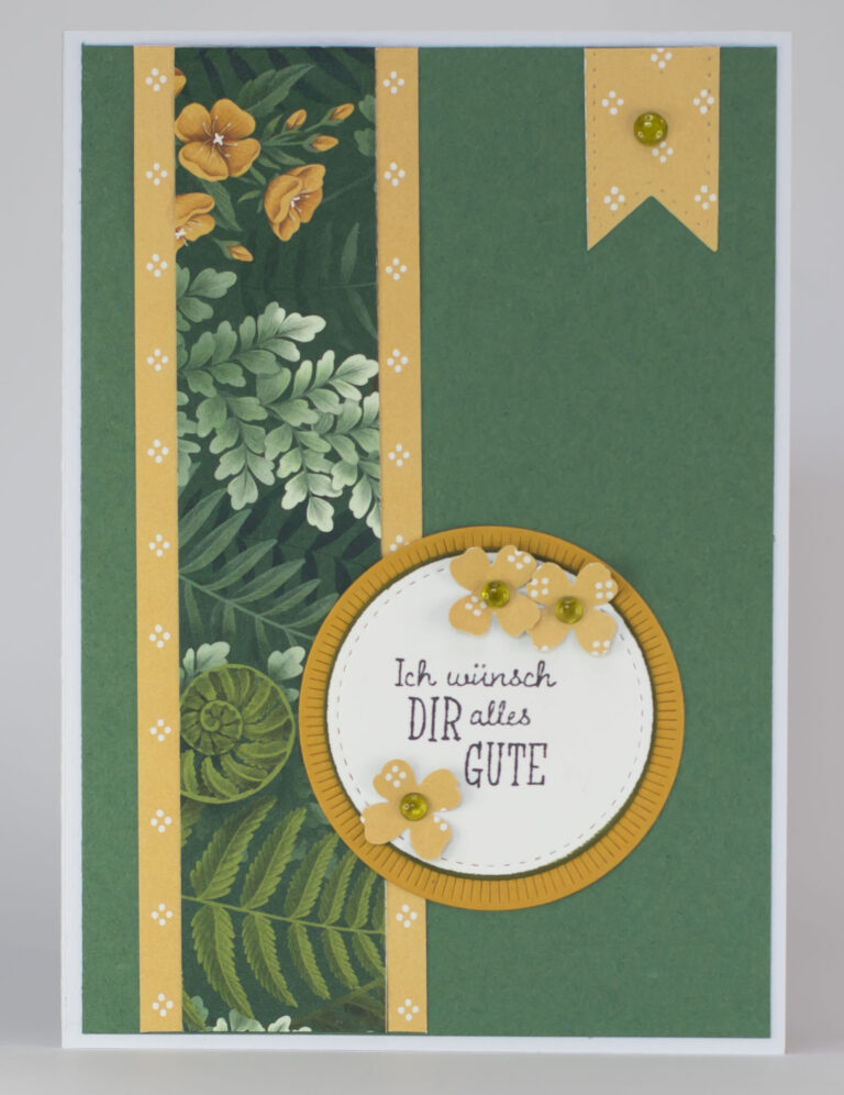 Grußkarte mit grünen und gelben Blumenmustern; der deutsche Text im Kreis lautet „Ich wünsch dir alles Gute“ und ist mit kleinen Blumen und grünen Verzierungen geschmückt – die perfekte Inspiration für dein nächstes „Mach was draus“-Projekt am 26. August.