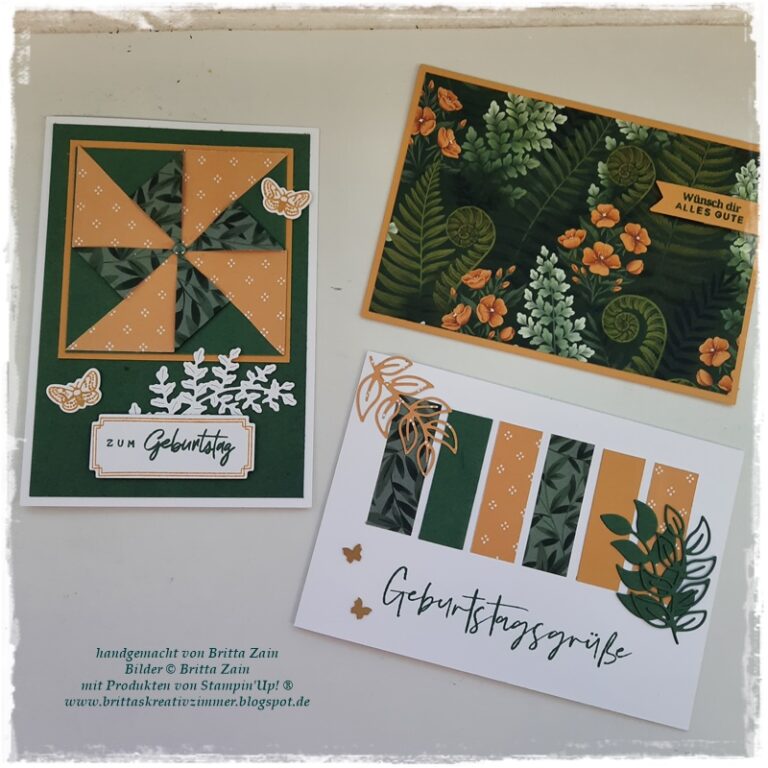Drei handgefertigte Grußkarten mit botanischen Motiven in Grün, Orange und Weiß, versehen mit deutschen Geburtstagsgrüßen und Blumenmotiven, die von „Mach was draus – 26. August“ inspiriert sind und auf einem weißen Hintergrund angeordnet sind.