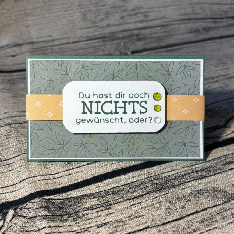 Eine von Mach inspirierte, handgefertigte Karte wurde am 26. August veröffentlicht. Darauf steht der deutsche Text „Du hast dir doch NICHTS gewünscht, oder?“ auf einem grauen, mit Blättern verzierten Hintergrund mit einem gelben Band und zwei grünen Schmucksteinen.